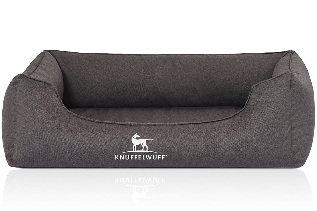 Graues Hundebett mit erhöhtem Rand. Logo "Knuffelwuff" auf der Vorderseite. Rechteckige Form mit abgerundeten Ecken.