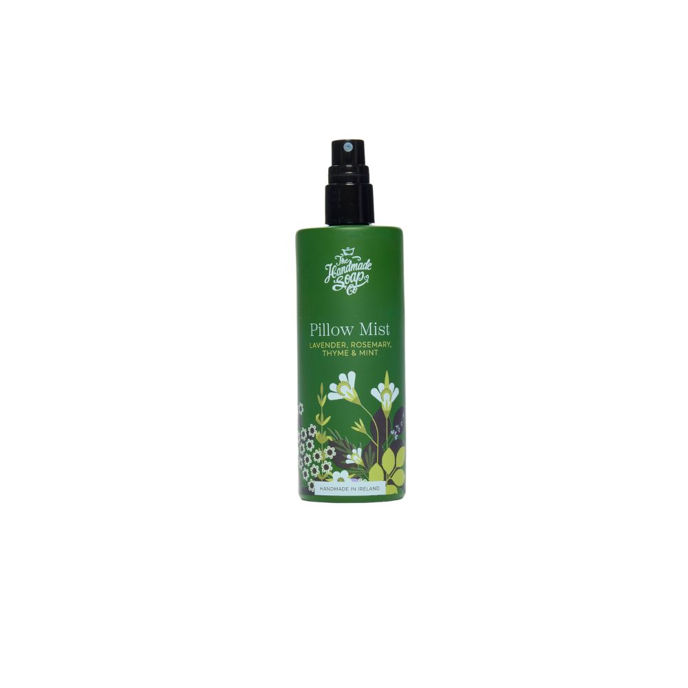 Grüne Flasche mit schwarzem Sprühkopf. Aufschrift: Pillow Mist, Lavendel, Rosmarin, Thymian & Minze. Floral-Dekor.