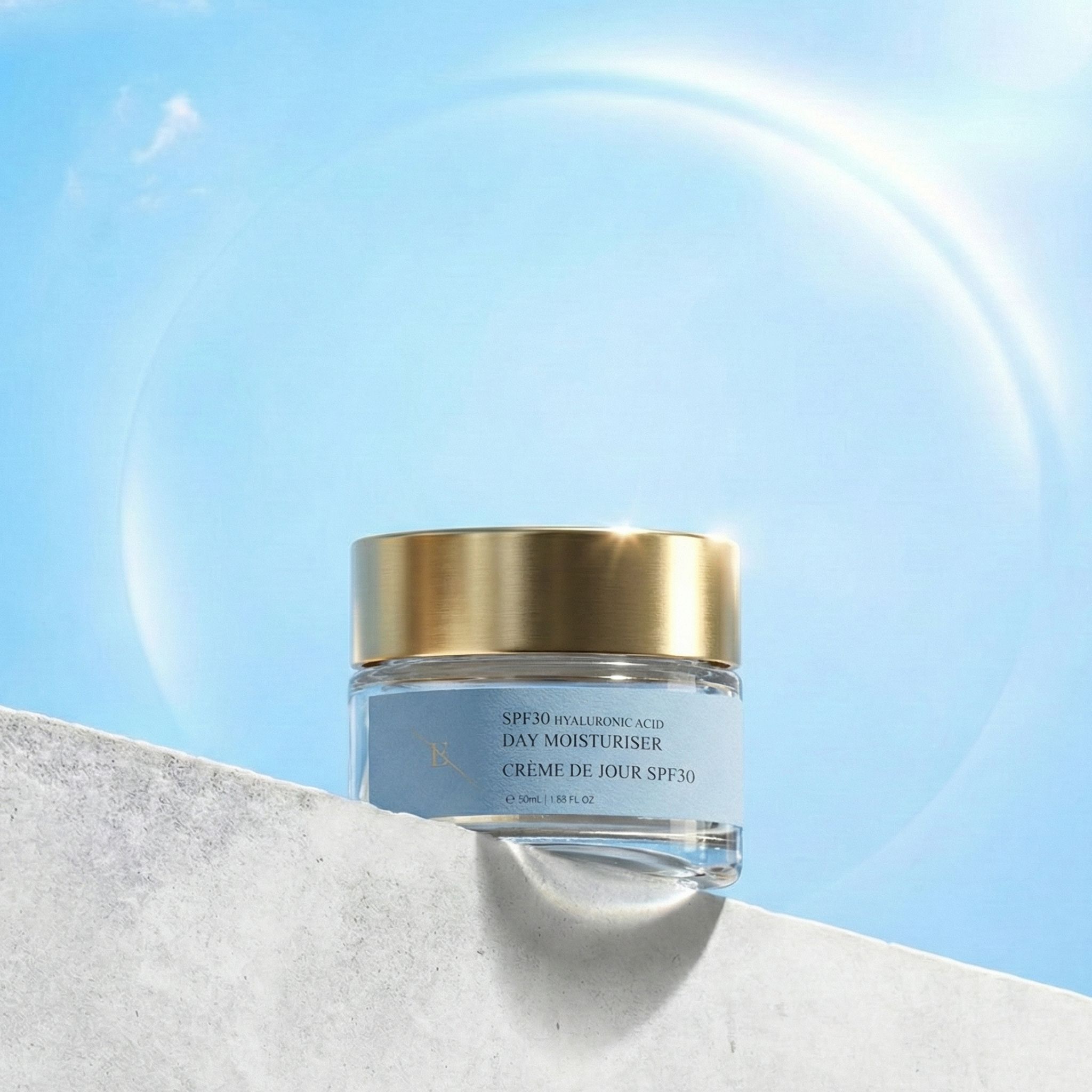 Tagescreme-Tiegel mit goldenem Deckel vor blauem Himmel. Aufschrift: SPF30 Hyaluronsäure Day Moisturiser, Crème de Jour SPF30.