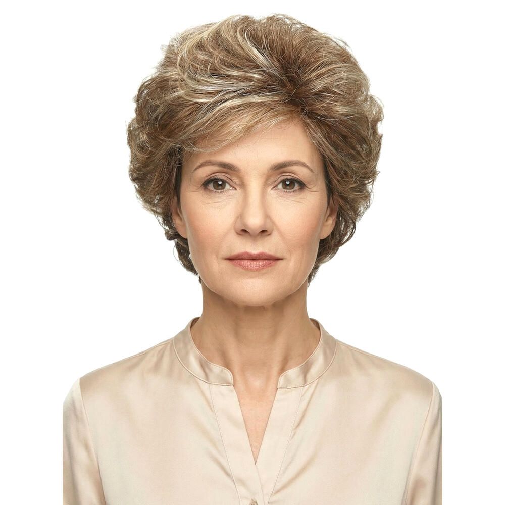 Perücke MONACO. Blond-meliertes Kunsthaar. Frontale Ansicht einer Frau. Sie trägt eine beige Bluse. Der Hintergrund ist weiß.