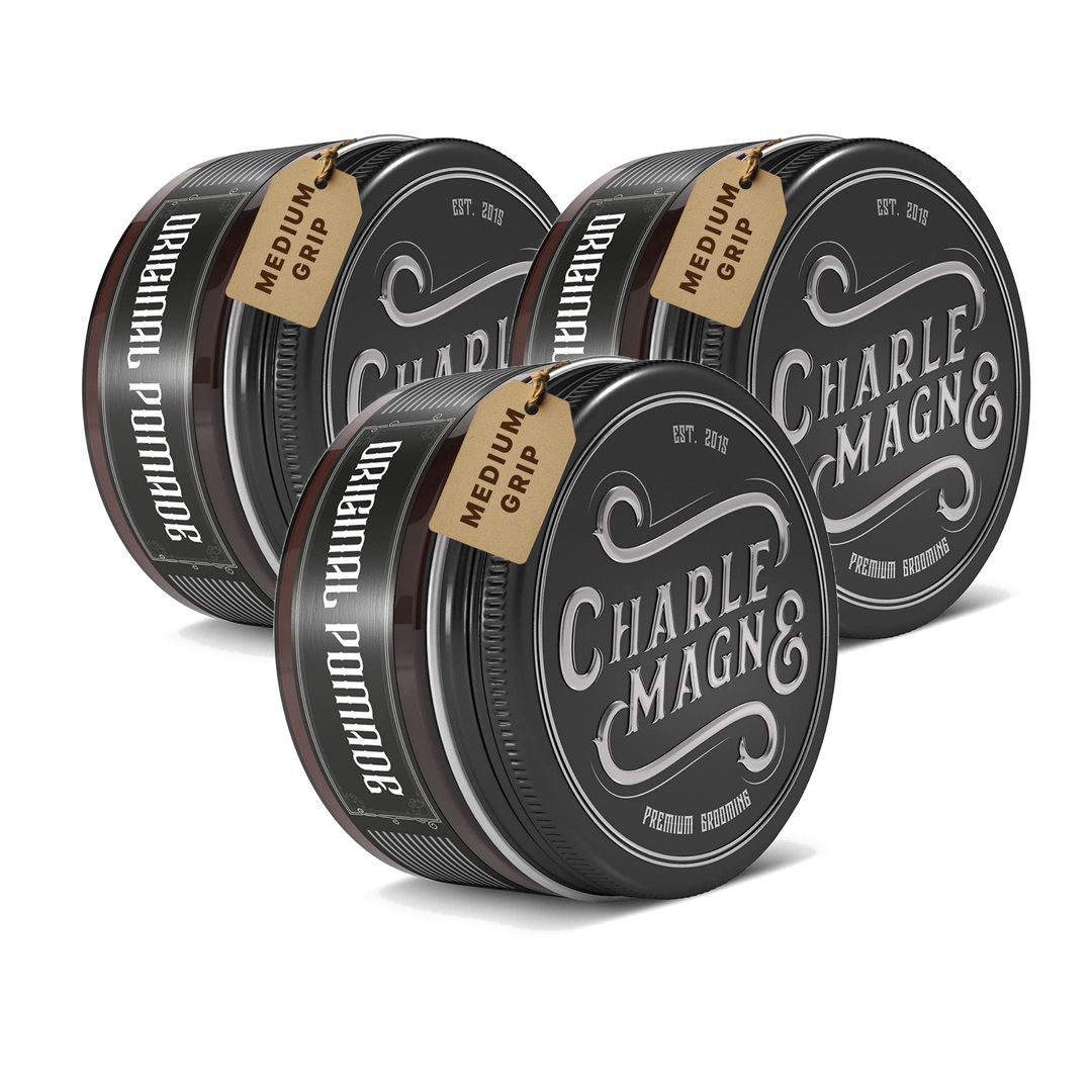Drei runde Dosen mit schwarzen Deckeln, Etiketten mit "CHARLE MAGN&" und "ORIGINAL POMADE".