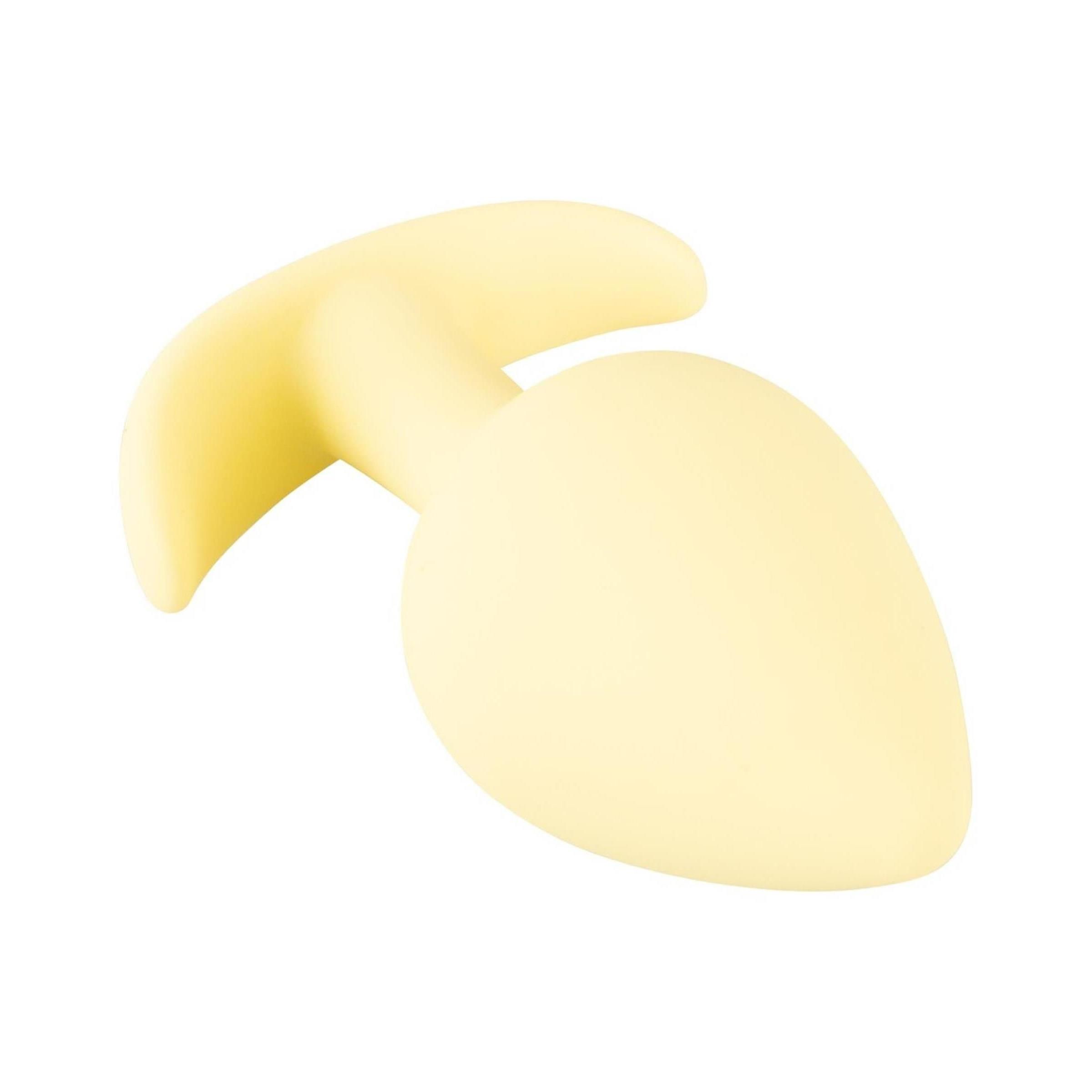 Gelber, tropfenförmiger Analplug mit gebogener Basis. Aus weichem Material.