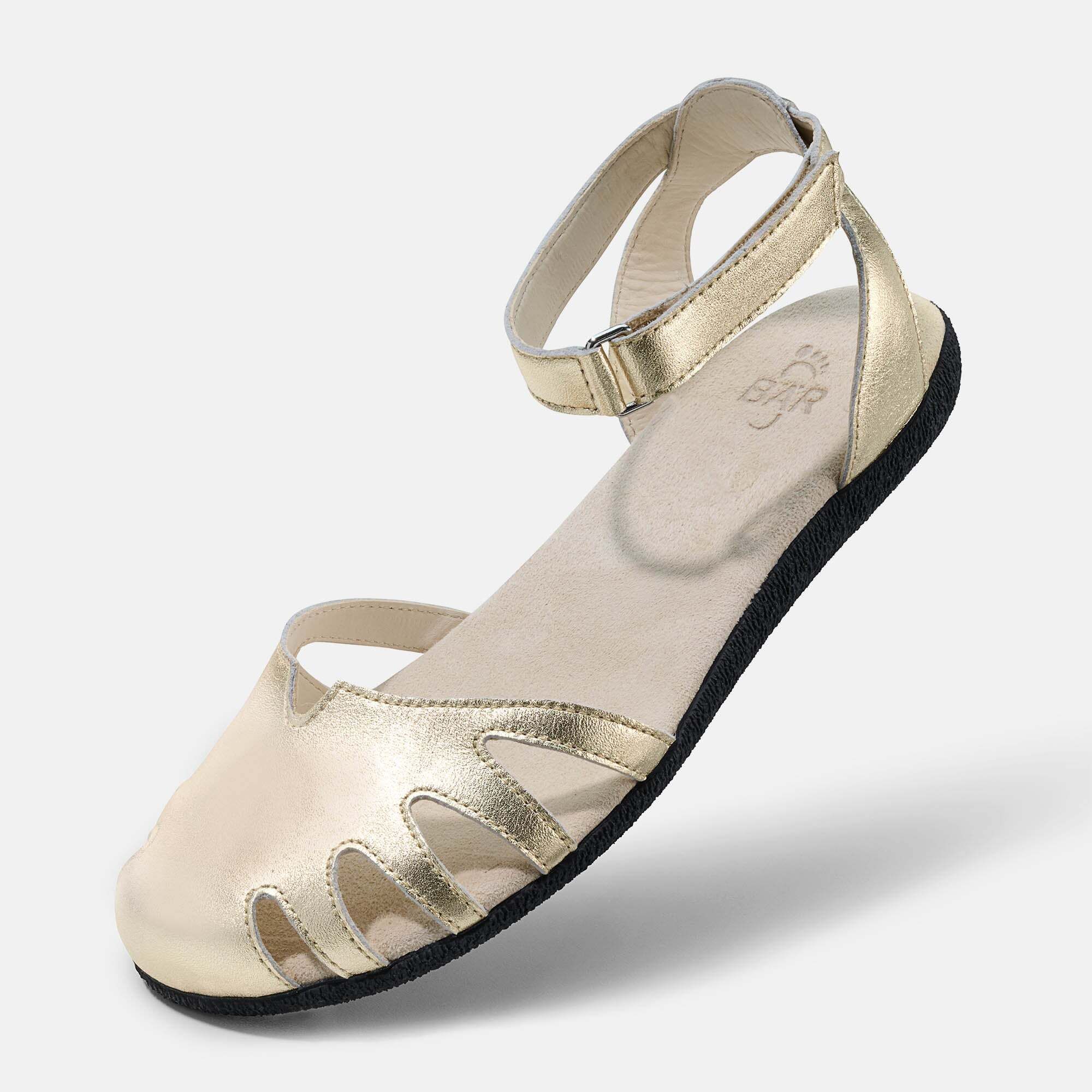 Goldene Damen-Sandale mit verstellbarem Knöchelriemen, seitlichem Ausschnitt und flachem Absatz.