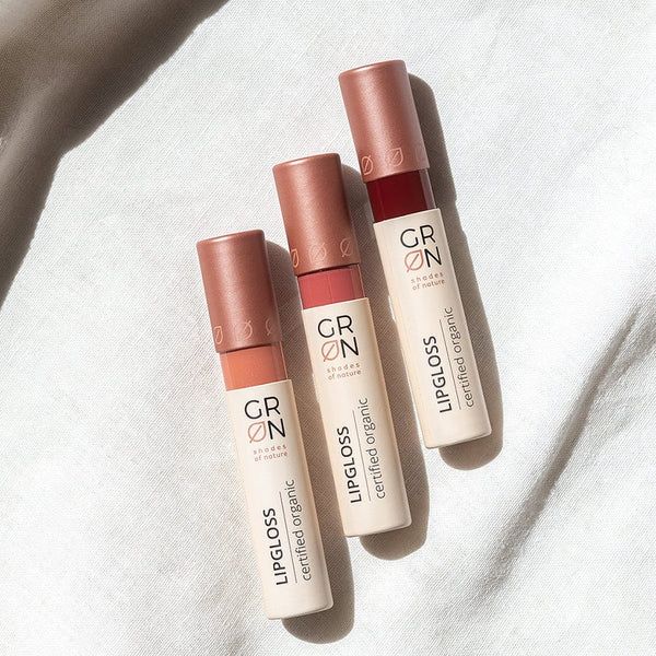 Drei GRN Lipgloss-Tuben. Aufschrift: LIPGLOSS, certified organic. Farbnuancen: Rosa, Koralle, Rot.