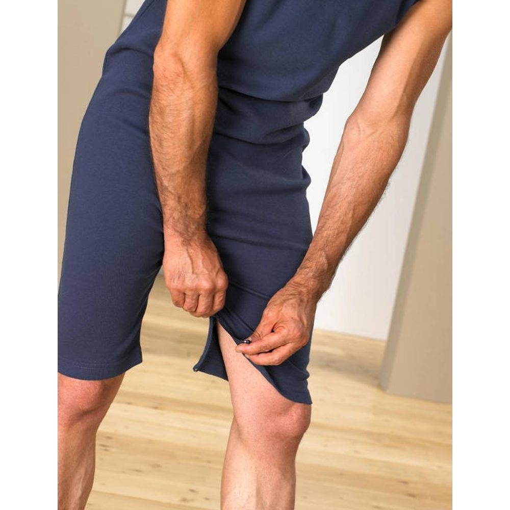 Nahaufnahme des blauen Overalls. Reißverschluss an der Beinseite wird geöffnet. Kurze Beine.