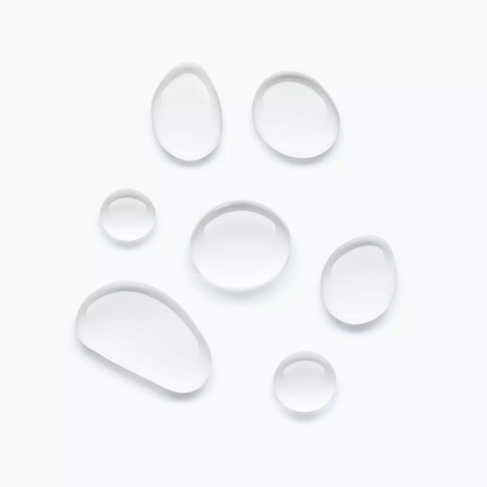 Sieben klare, ovale Tropfen auf weißem Hintergrund.