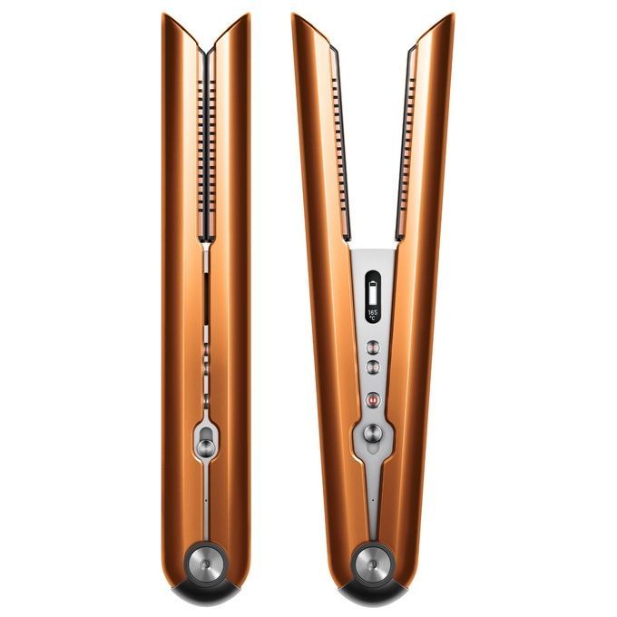 Piastra per capelli Dyson Corrale color rame e nichel. L'immagine mostra la piastra aperta, rivelando le piastre riscaldanti. Sul manico sono presenti comandi e un display. La forma è ergonomica e il design moderno.