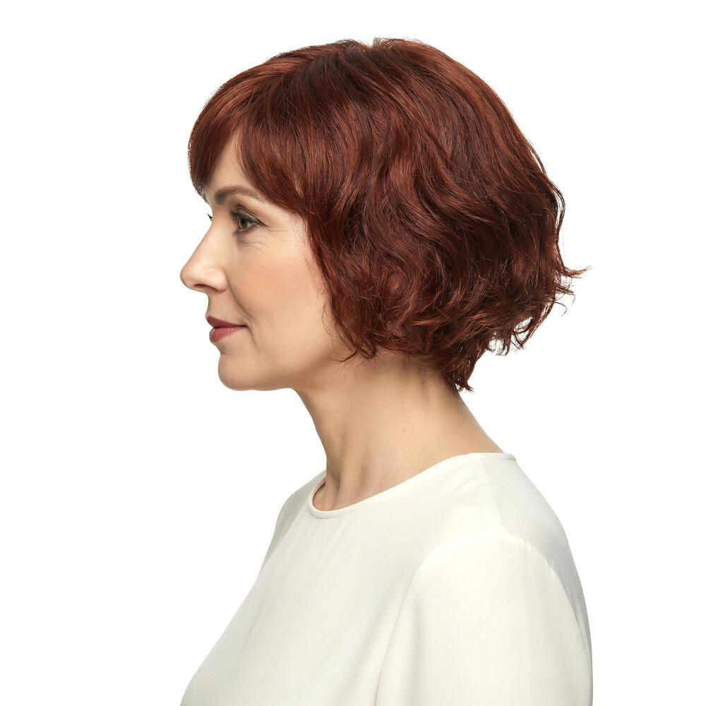 Profil einer Frau mit rotbrauner, gewellter Perücke. Weißer Hintergrund.