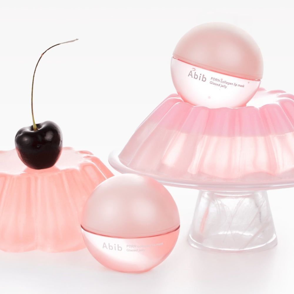 Drei rosa kugelförmige Behälter mit Deckel. Auf einem steht ein Kirsche. Auf einem steht ein Produkt mit dem Namen Abib.