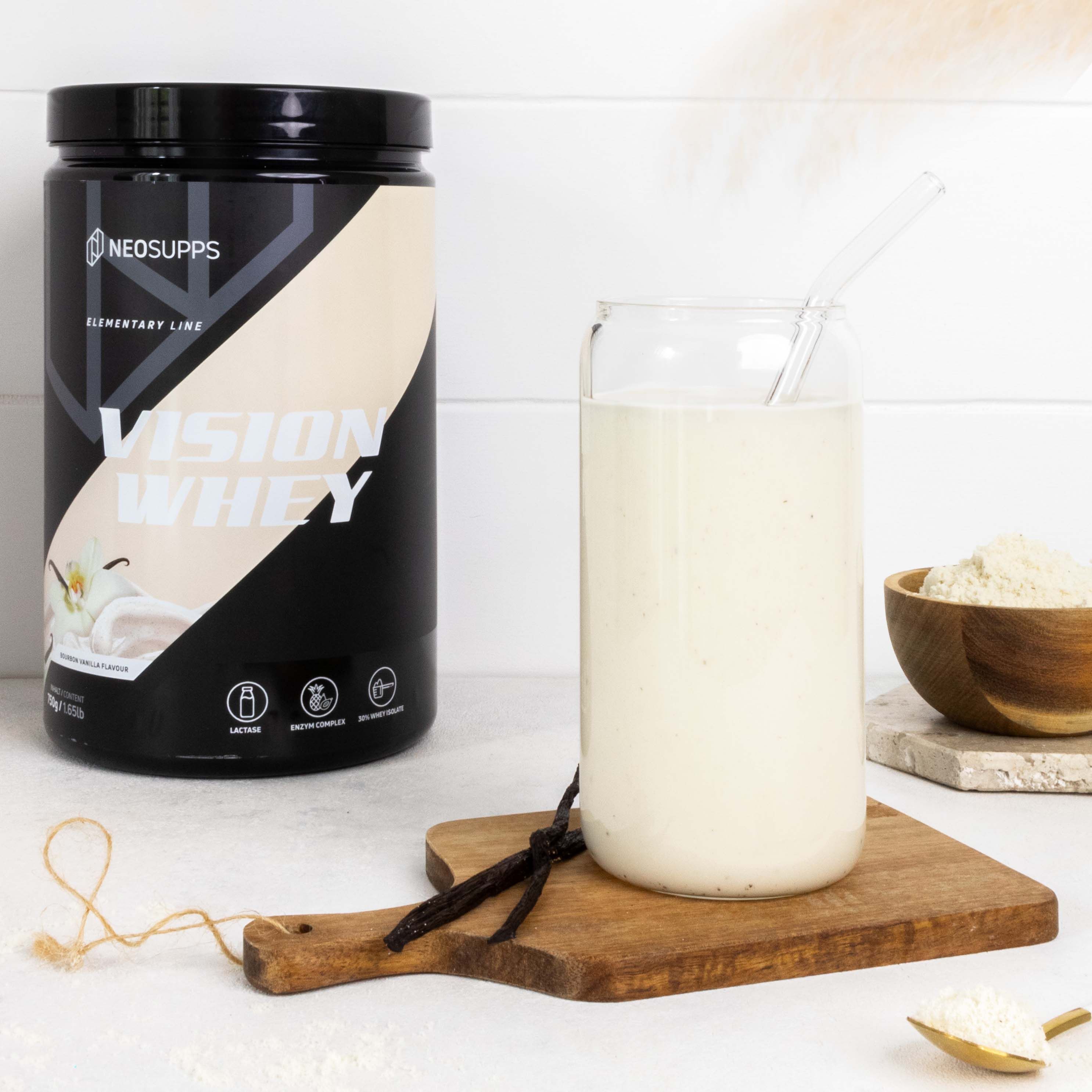 Schwarze Dose Neosupps Vision Whey neben Glas mit Shake. Vanilleschote auf Holzbrett. Text: Vision Whey, Laktase.