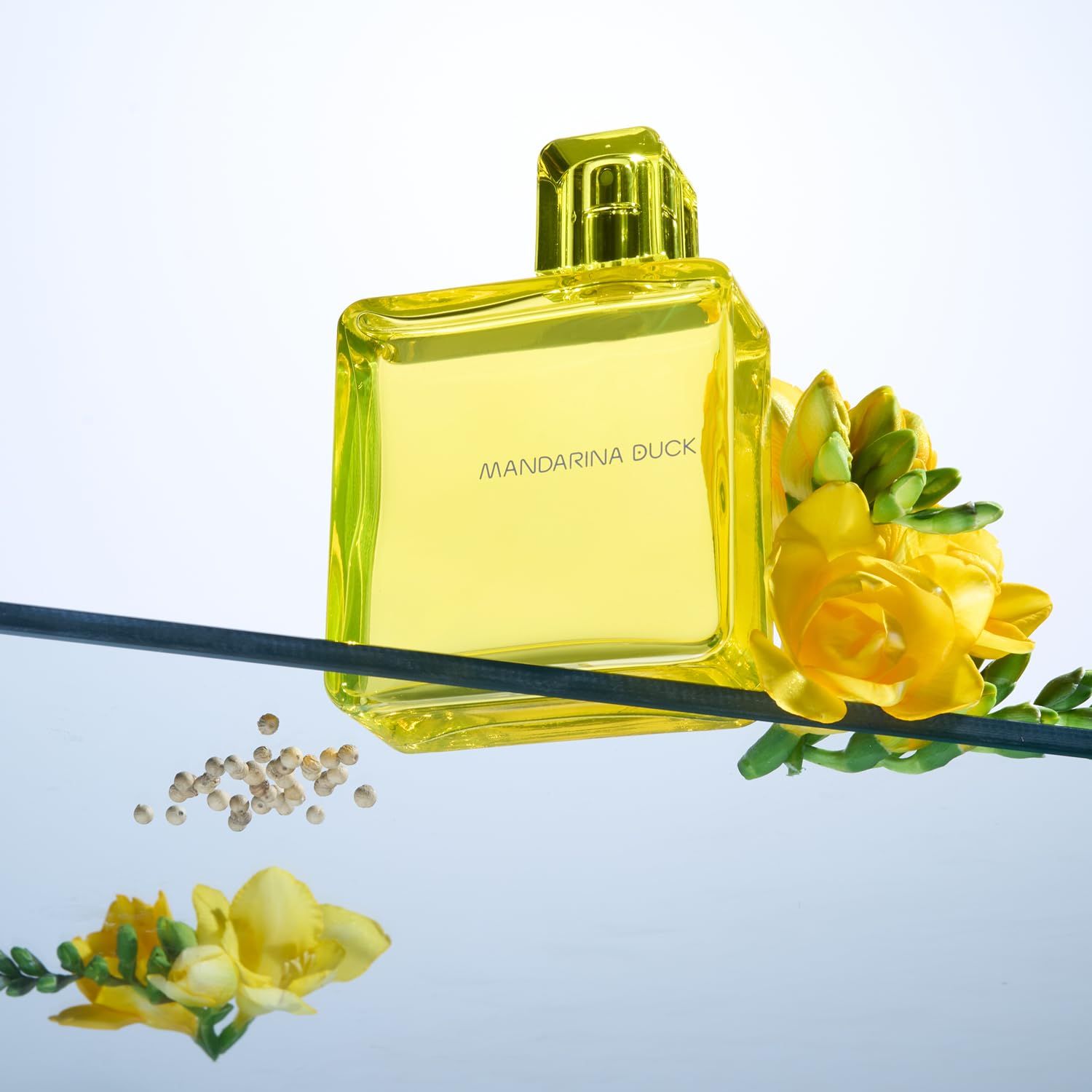 Gelbes Eau de Toilette Spray. Flasche mit gelbem Verschluss. Schriftzug Mandarina Duck. Mit Blumen.