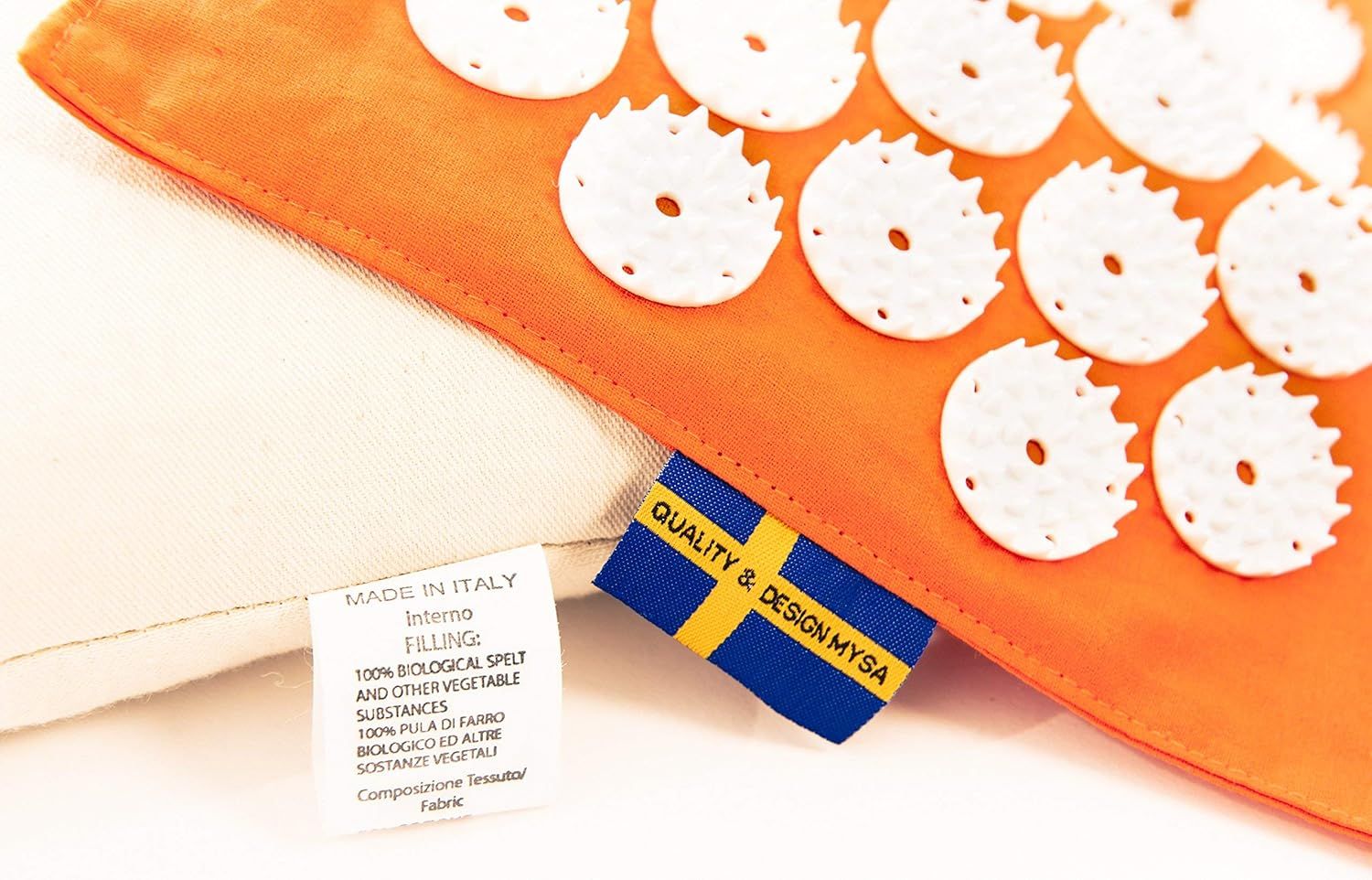 Detailansicht: Orangefarbenes Kissen mit weißen Noppen. Etiketten mit Text: 'Made in Italy' und 'Quality & Design Mysa'.