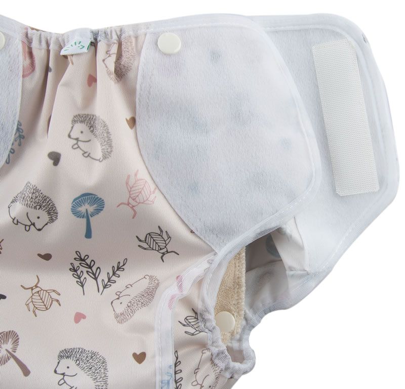 Detailansicht der Windel. Beige Stoff mit Waldmuster. Druckknöpfe und Klettverschluss. Innenseite mit weichem Material.