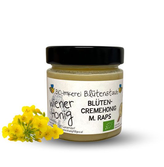 Glas mit Honig, schwarzem Deckel und Etikett. Gelbe Blüten daneben. Aufschrift: Wiener Honig, Blütencremehonig M. Raps, Bio-Imkerei Blütenstaub.