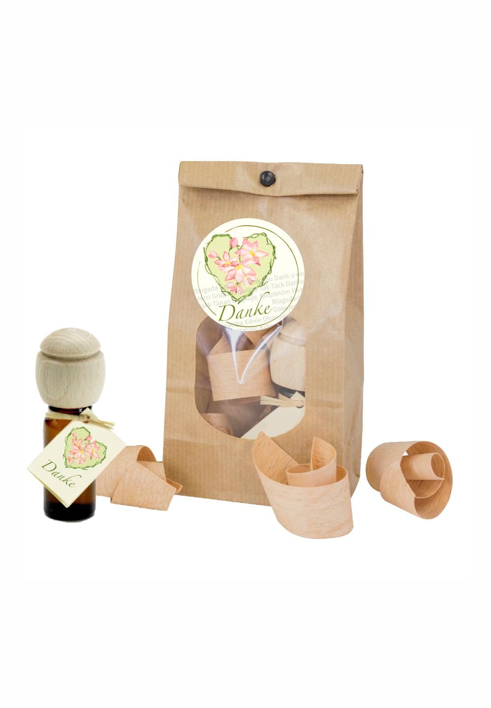 Geschenkset mit brauner Papiertüte, Holzspänen, einer Flasche mit Holzaufsatz und Anhänger. Aufkleber mit floralem Motiv.