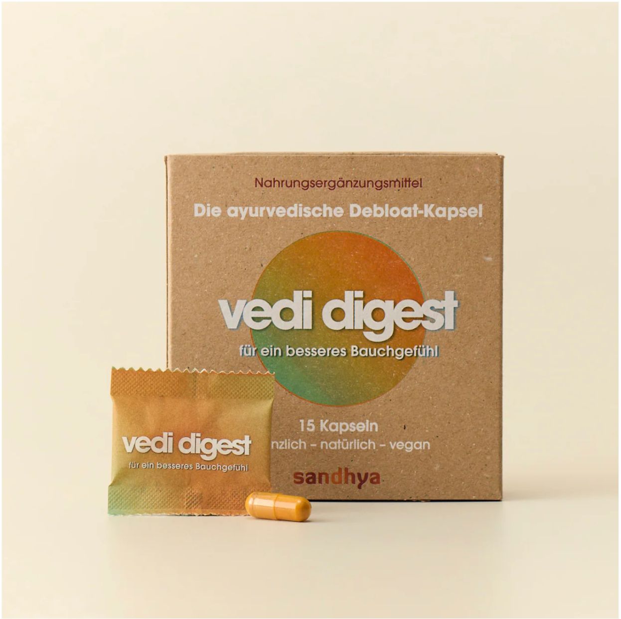 Braune Schachtel und Beutel mit "vedi digest"-Logo. Eine Kapsel liegt daneben. Text: "15 Kapseln", "vegan".