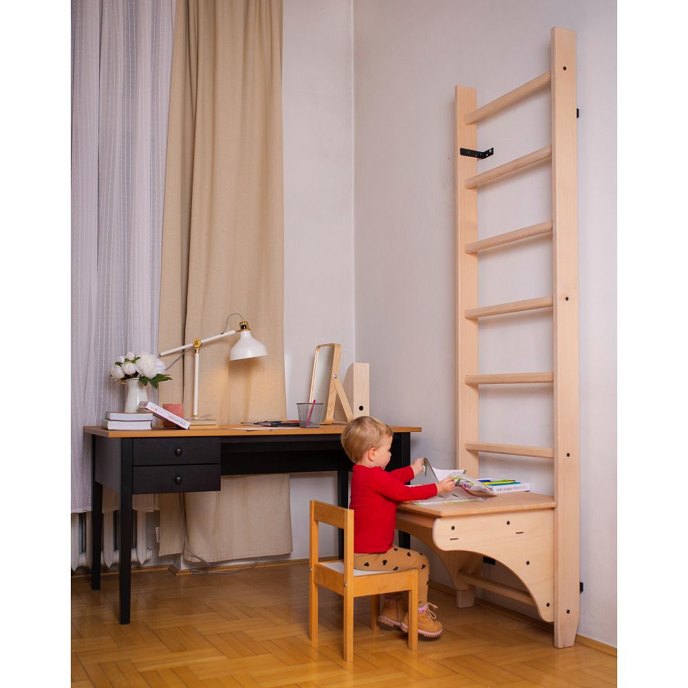 Kind am Schreibtisch des Holz-Klettergerüsts.