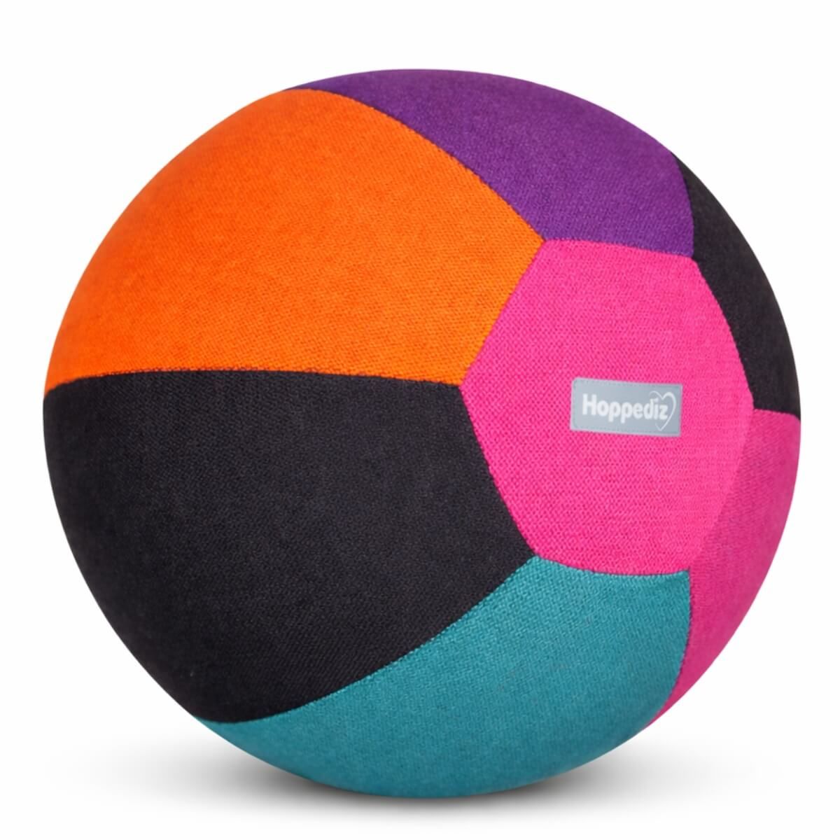 Bunter Stoffball mit sechseckigen Feldern in Orange, Schwarz, Pink, Lila, Türkis. Kleines Hoppediz-Label.