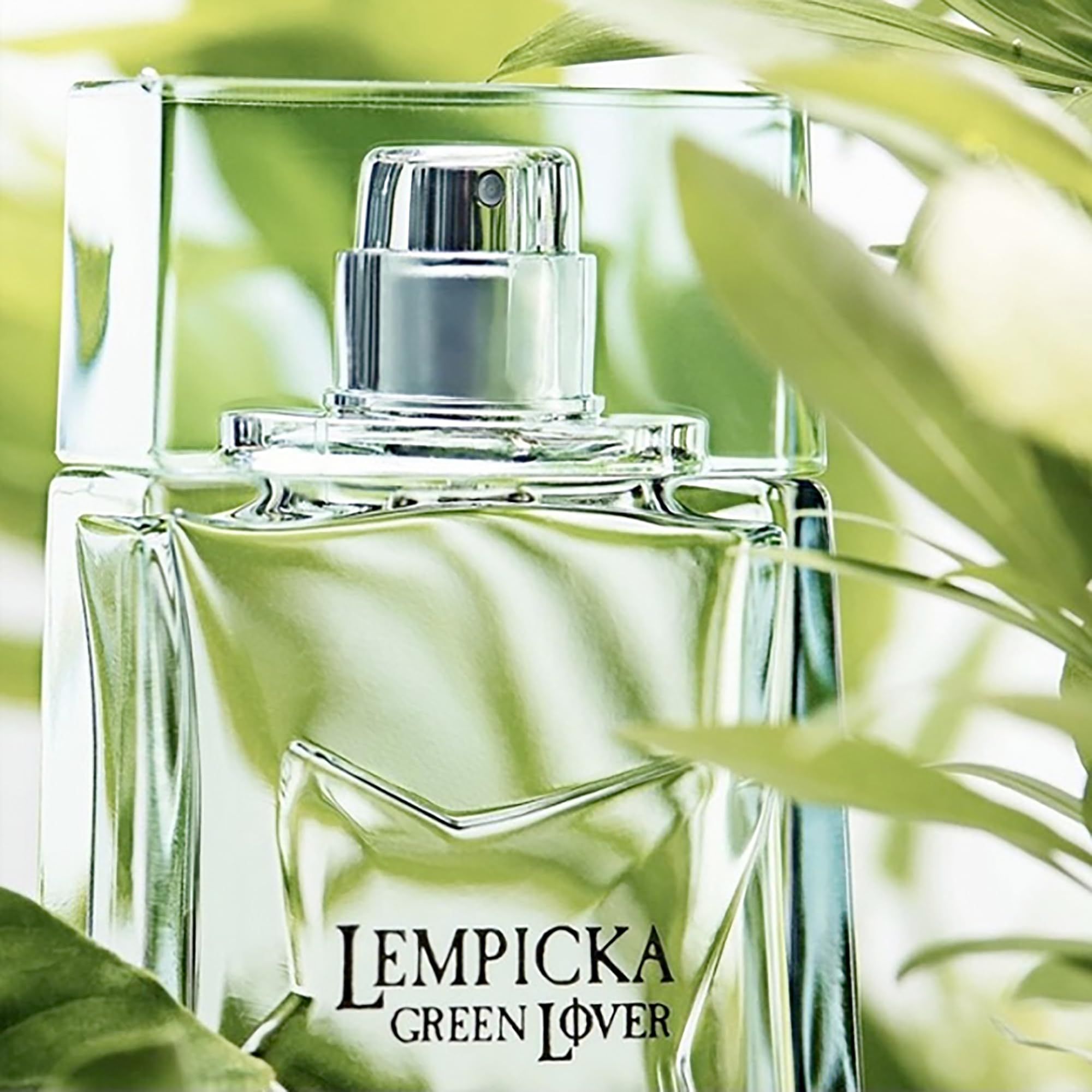 Flakon mit grünem Duft, umgeben von grünen Blättern. Aufschrift: Lempicka Green Lover.