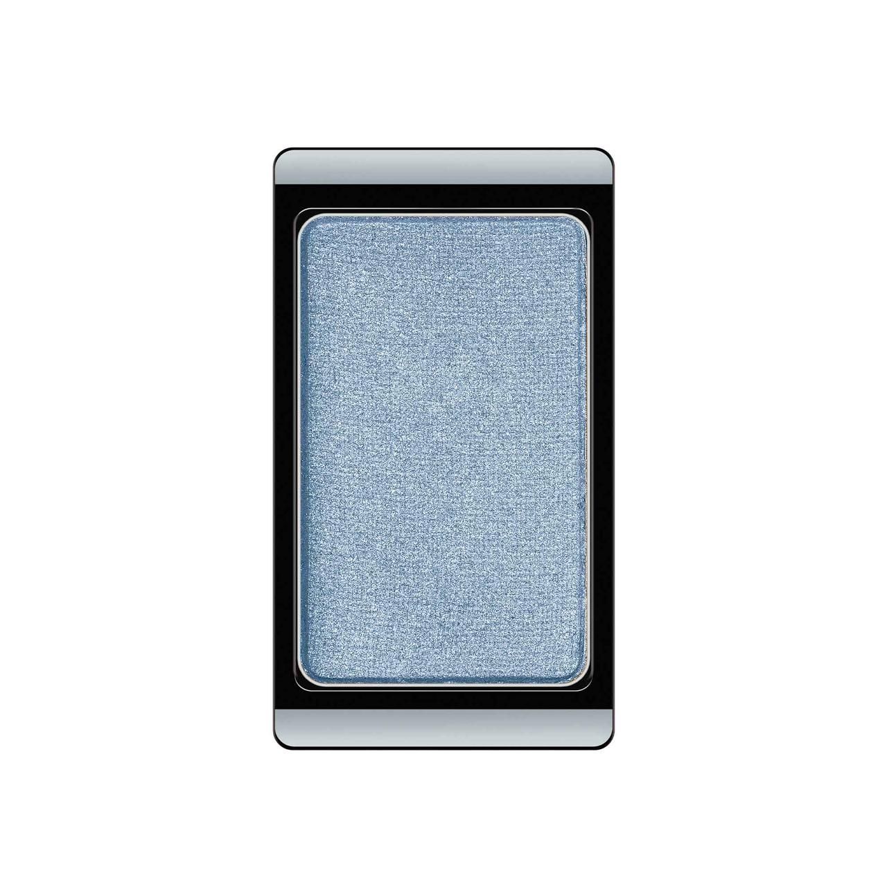 Einzelner blauer Lidschatten in einer rechteckigen, schwarzen und silbernen Hülle. Produktansicht von oben.