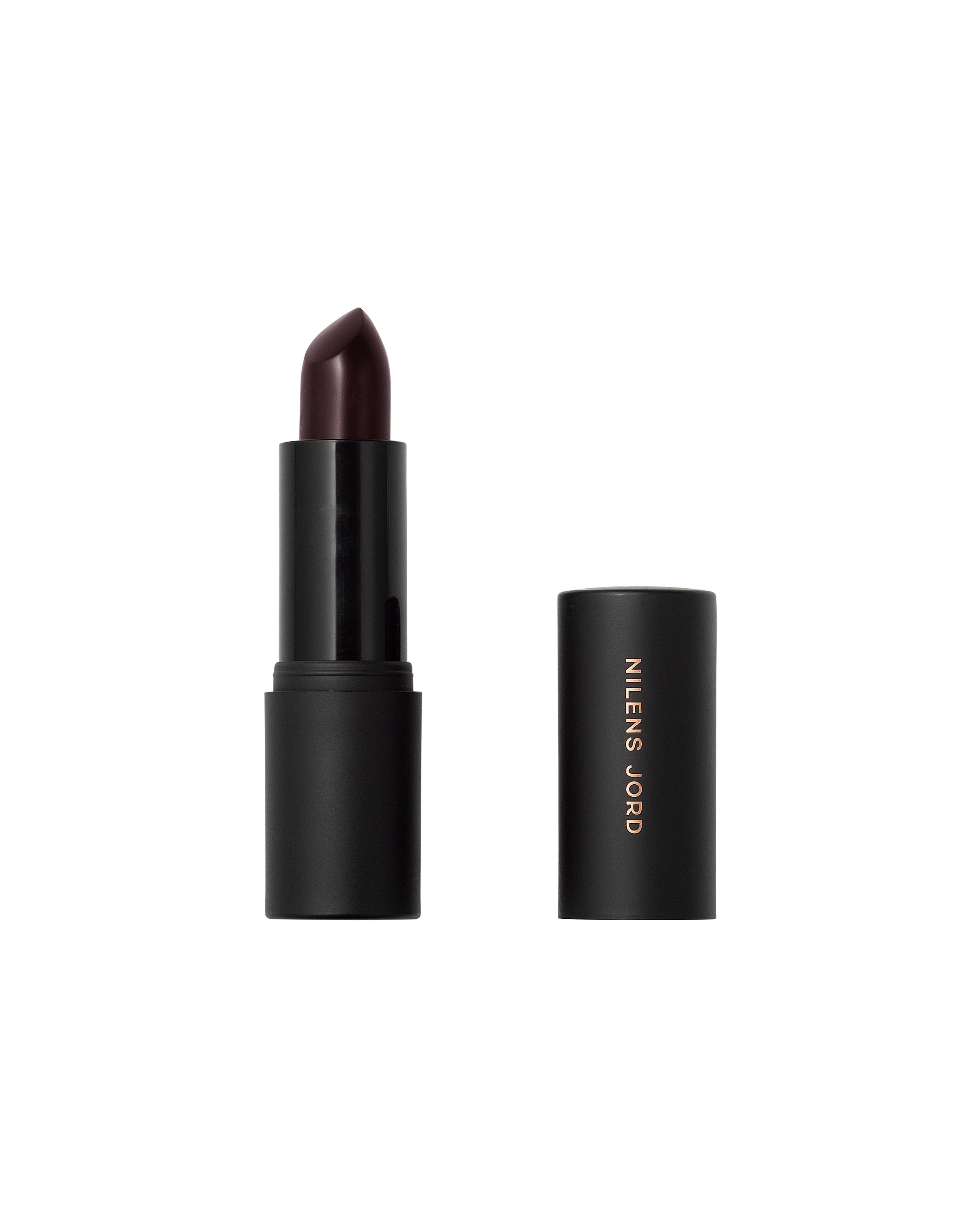 Schwarzer Lippenstift mit dunklem, glänzendem Braunton. Der Deckel mit dem Markennamen "Nilens Jord" liegt daneben.