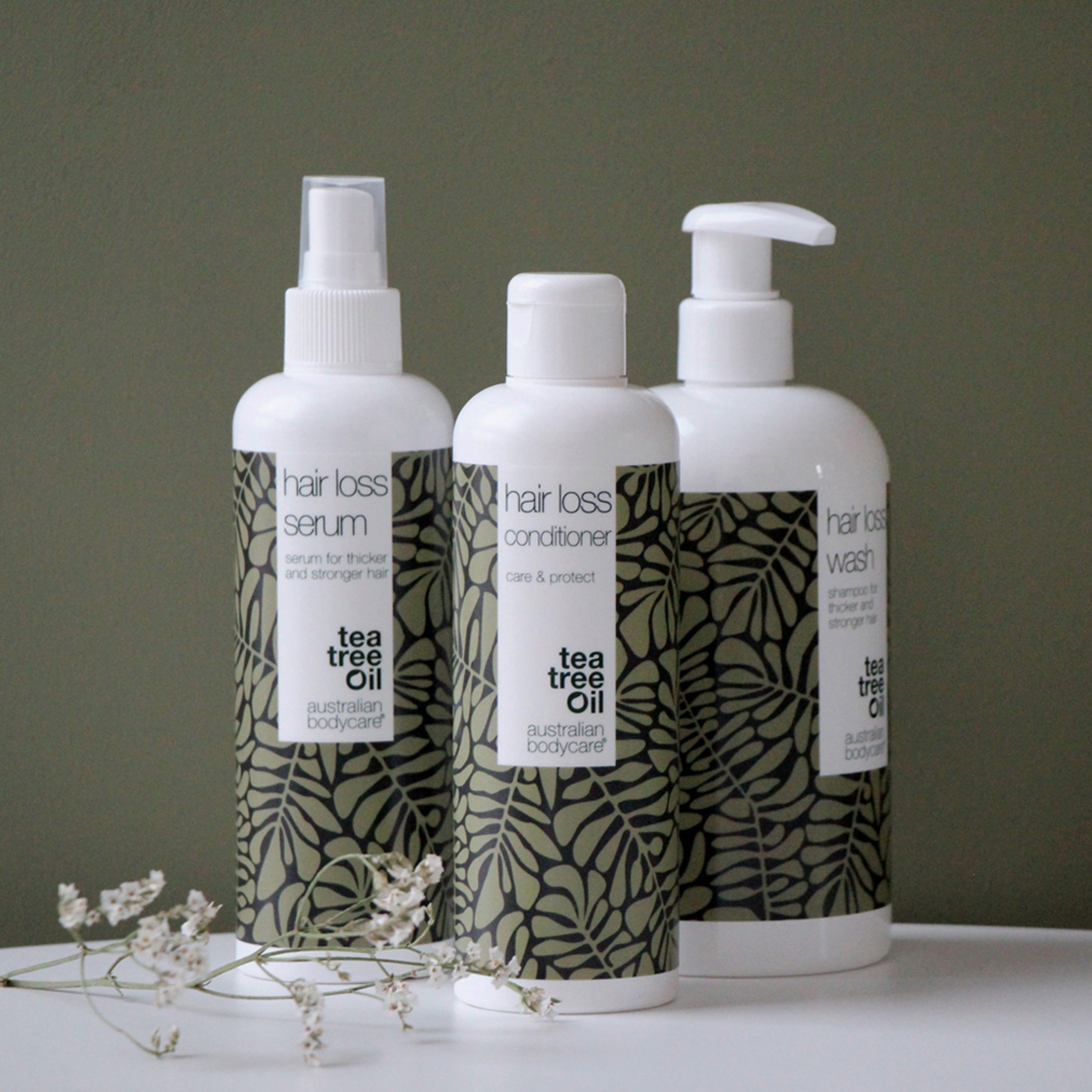 Tre bottiglie e tubi. Testo: Hair Loss Serum, Hair Loss Conditioner, Hair Loss Wash, Tea Tree Oil, Australian Bodycare.