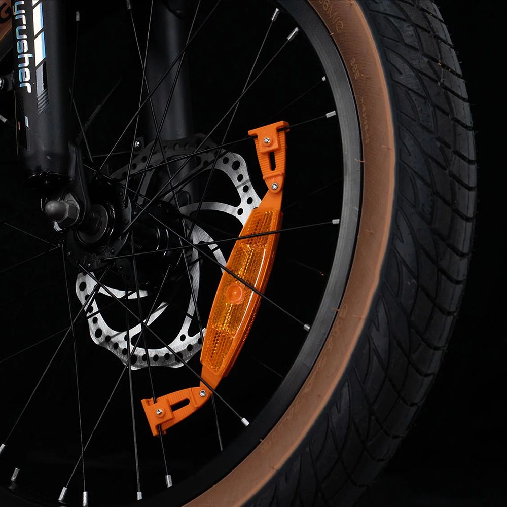 Fahrradreifen mit orangefarbenem Reflektor. Scheibenbremse und CYRUSHER-Logo sichtbar.