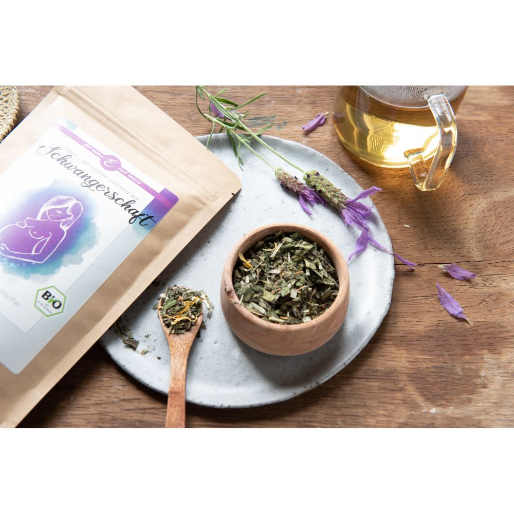 Produktverpackung, Schale mit Kräutern, Holzlöffel mit Kräutern, Lavendelzweige. Tee in Glas. Bio-Siegel auf Verpackung.