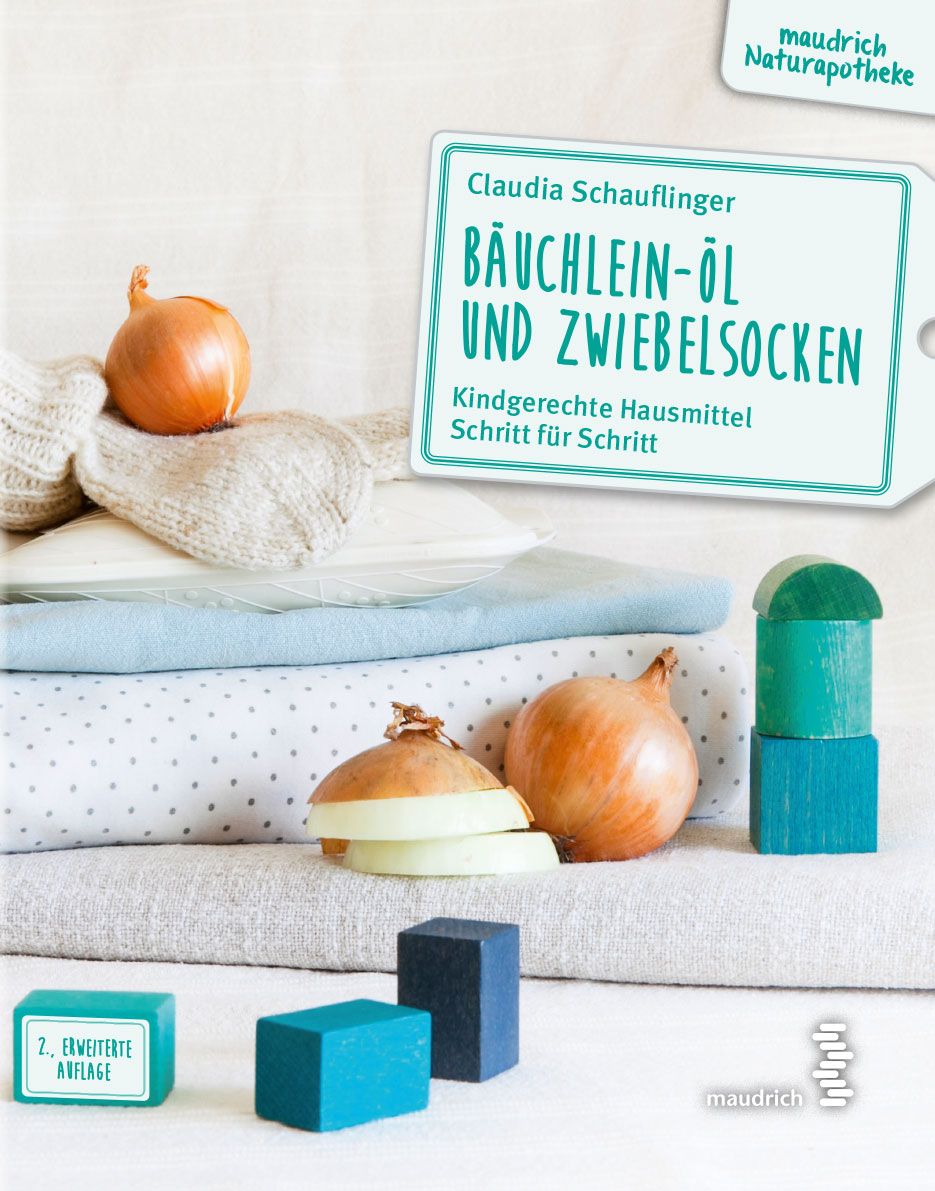 Buchcover mit Zwiebeln und Holzbausteinen. Titel: Bäuchlein-Öl und Zwiebelsocken. Autorin: Claudia Schauflinger. Verlag: maudrich Naturapotheke.