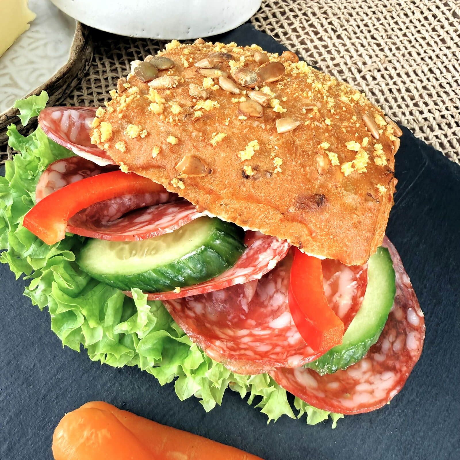 Locawo Flotty Karotty Brötchen belegt mit Salami, Salat, Gurke und Paprika.