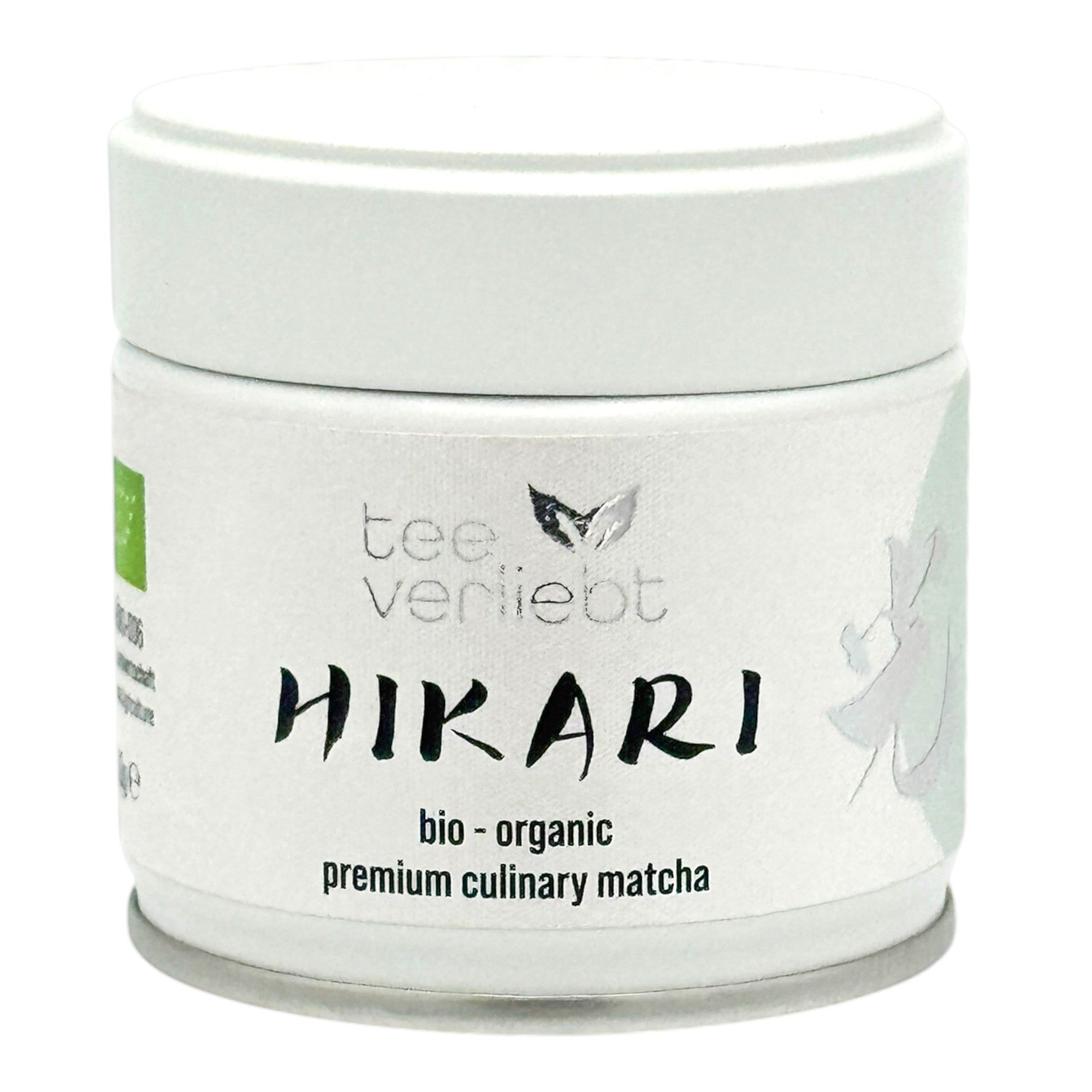 Weißes Dose mit "teeverliebt Hikari"-Aufdruck. "Bio-organic premium culinary matcha" Text. Grünes Bio-Siegel. Dose mit Deckel.