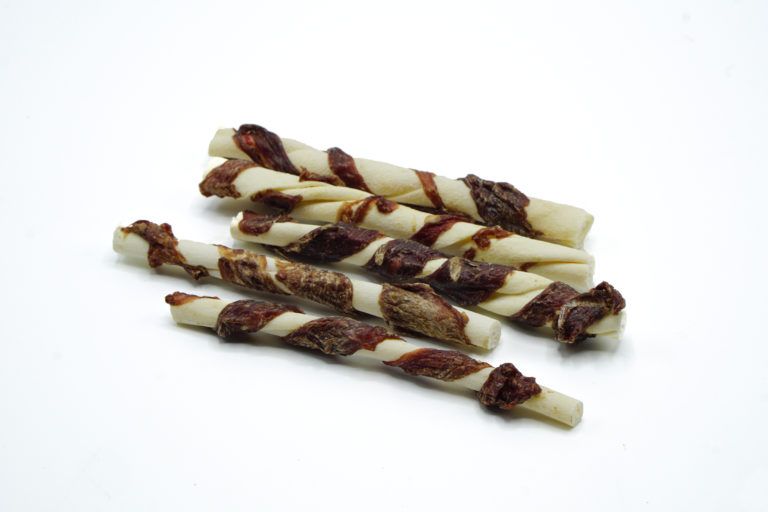 Mehrere gedrehte Kaustangen mit Rindfleisch. Weiß-braune Farbe. Auf weißem Hintergrund.