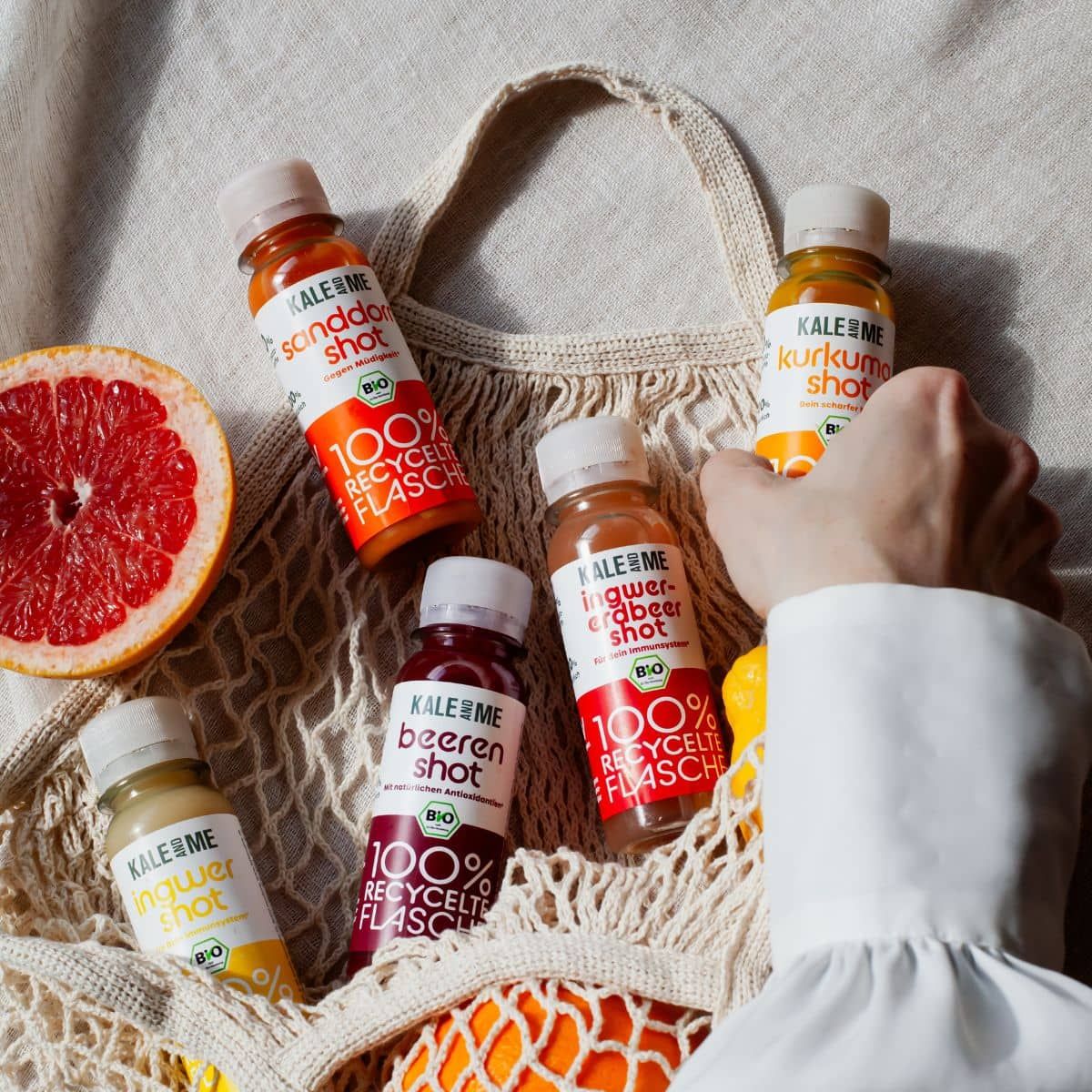 Fünf kleine Flaschen in einer Netztasche. Auf jeder Flasche steht "KALE ME" und der Name des Shots. Bio-Siegel.