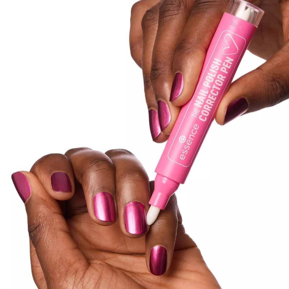 Eine Hand hält einen pinkfarbenen Essence Nagellack Korrekturstift. Der Stift wird auf einen lackierten Fingernagel angewendet. Auf dem Stift steht "THE NAIL POLISH CORRECTOR PEN".
