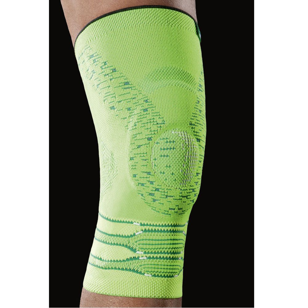 Hellgrüne Kniebandage. Details der Strickstruktur sichtbar. Schwarzer Abschluss am oberen Rand. Auf einem Bein getragen.