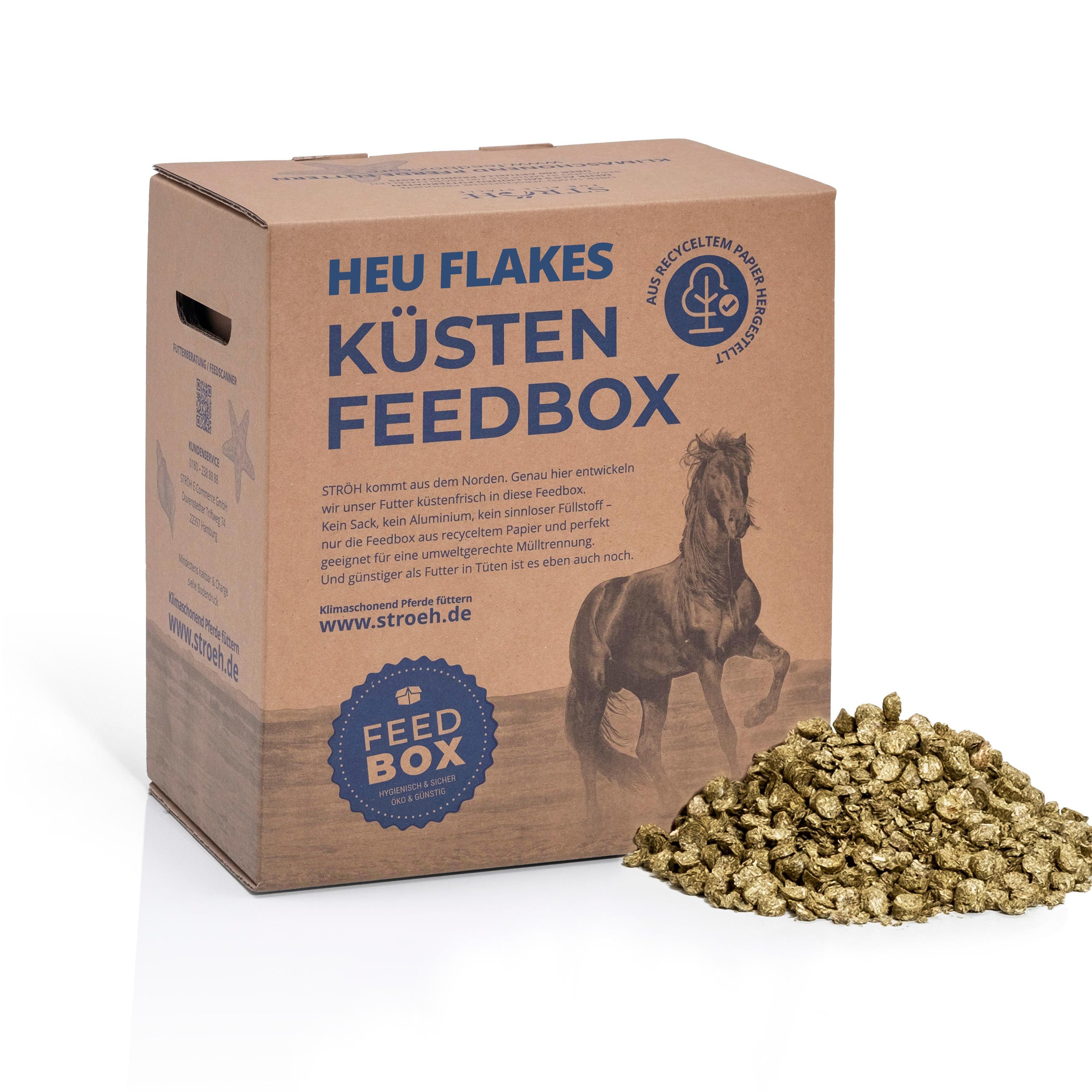 Karton "Heu Flakes Küsten Feedbox" mit Futterflocken. Text: Aus recyceltem Papier, für alle Ställe, Feedbox.