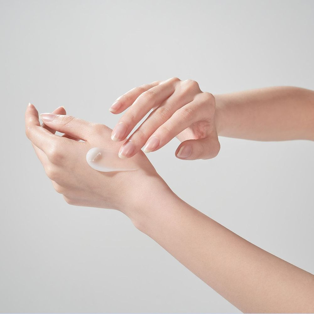 Hände tragen Creme auf. Weiße Creme auf der Hand. Hautpflege.