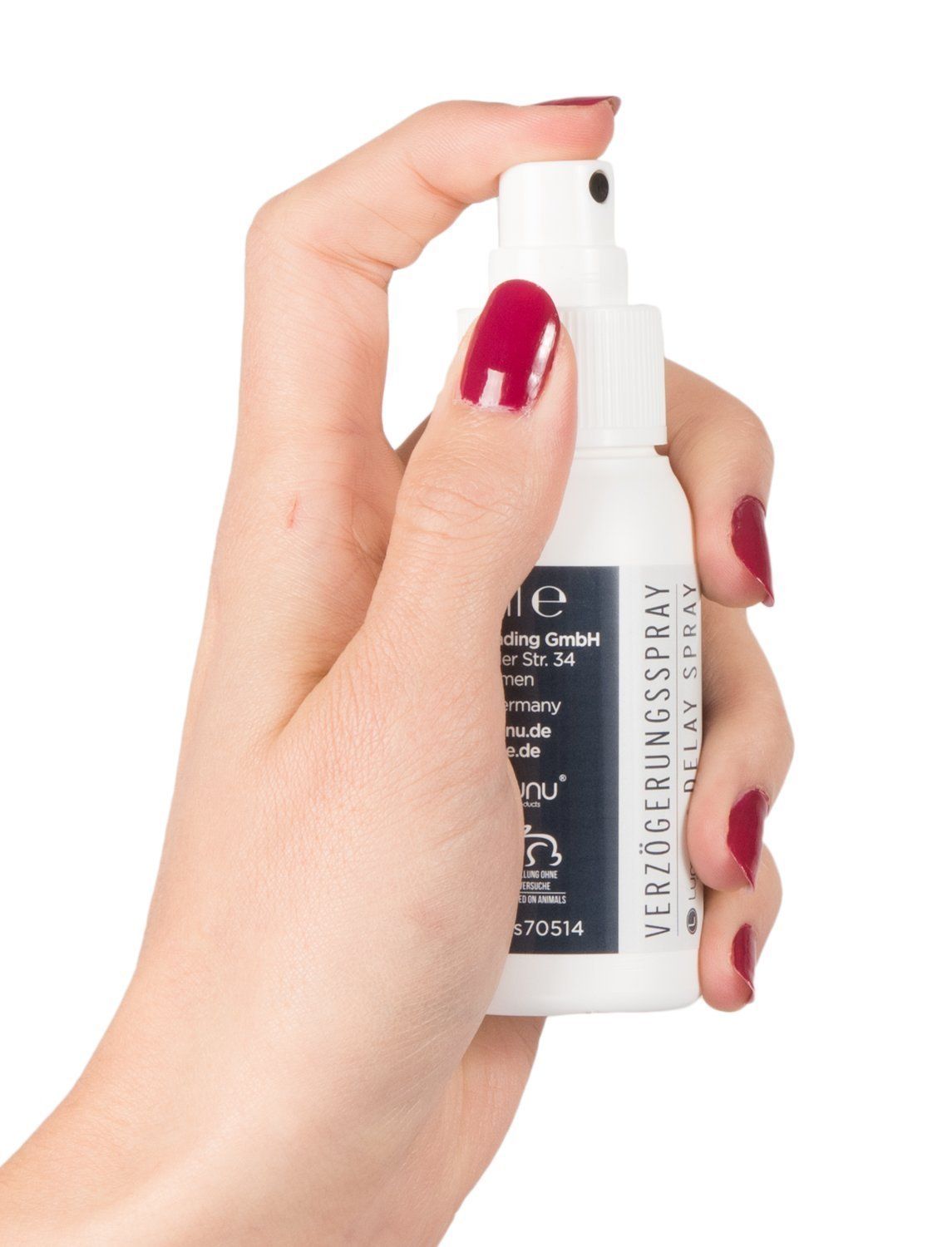 Hand hält eine weiße Sprühflasche mit der Aufschrift "Verzögerungsspray Delay Spray".