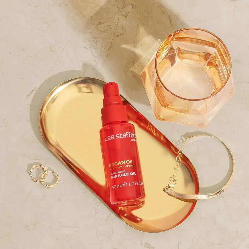 Rote Flasche Lee Stafford Argan Oil Miracle Oil, 50ml, auf goldenem Tablett.