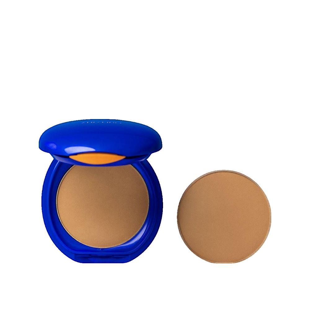 Kompaktpuder mit blauem Deckel, geöffnet. Daneben ein runder Puder. Helle Hautfarbe.