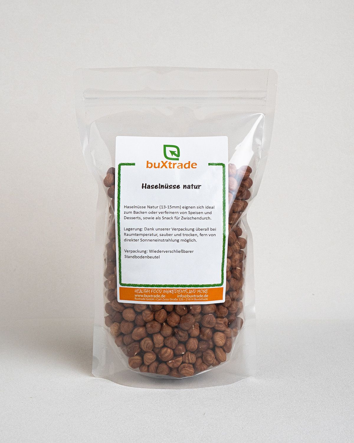 Transparente Verpackung mit buXtrade Haselnüsse Natur. Sichtbare Nüsse, Etikett mit Produktinformationen.