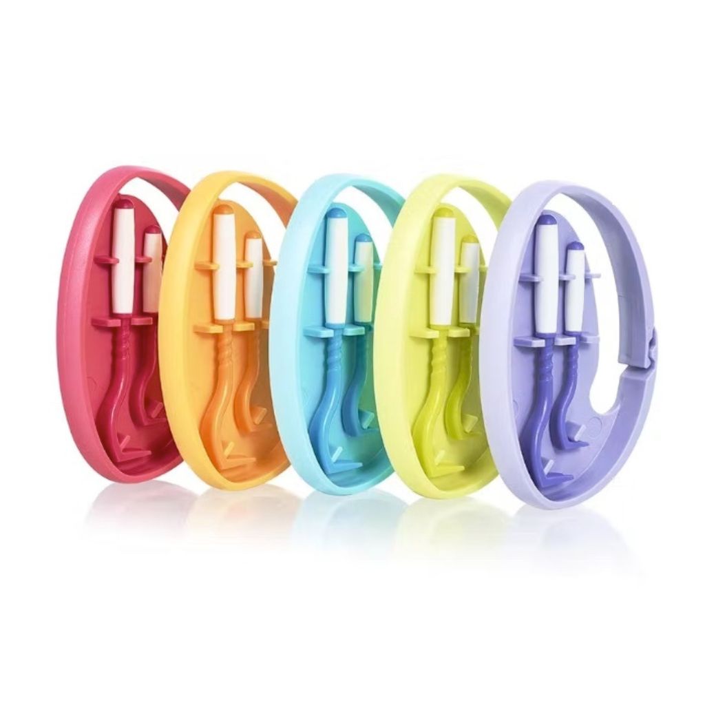 Fünf Clipboxen in verschiedenen Farben. Jede Box enthält zwei Zeckenhaken. Farben: pink, orange, blau, gelb, lila.