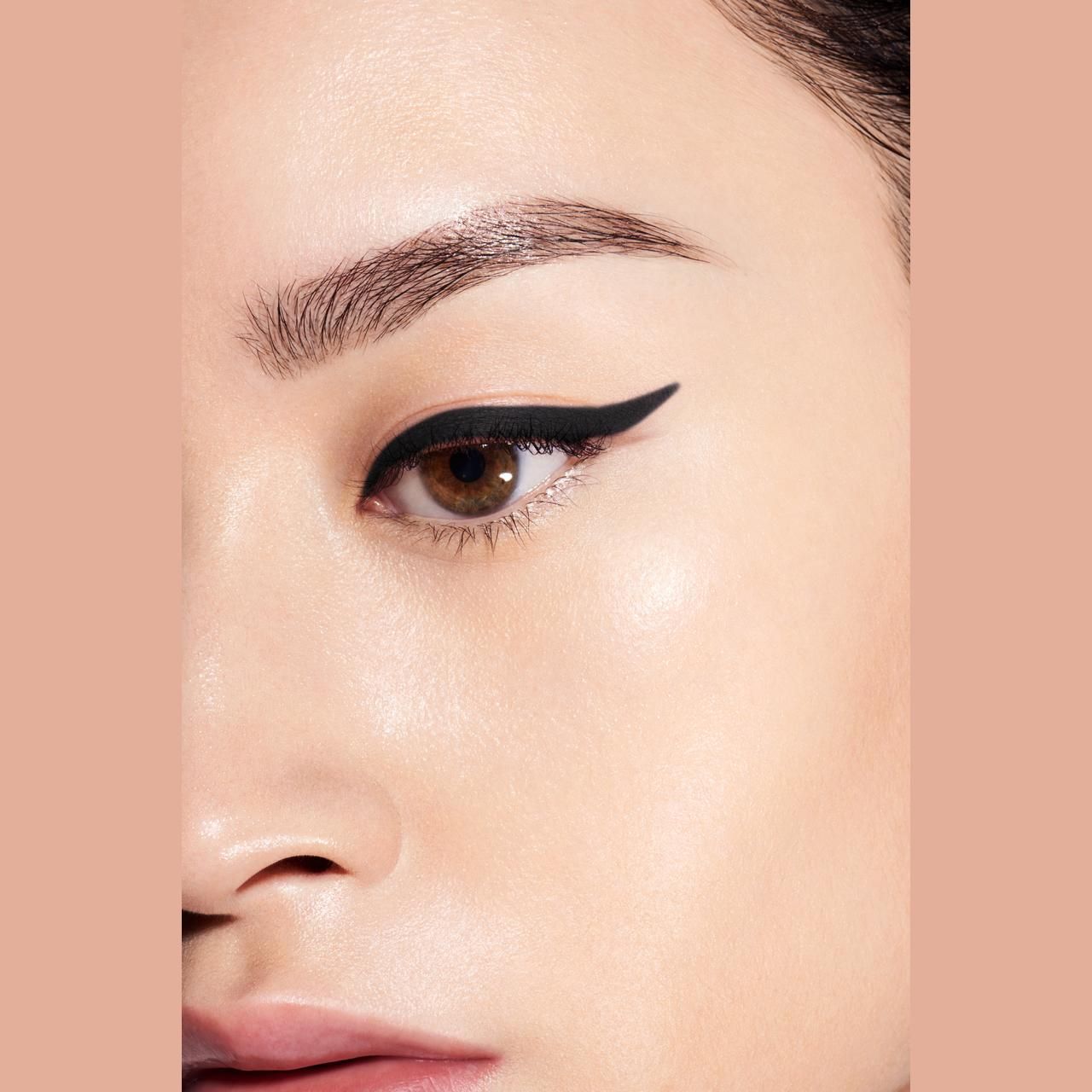 Nahaufnahme eines Auges mit schwarzem Eyeliner. Hautton: hellbraun.
