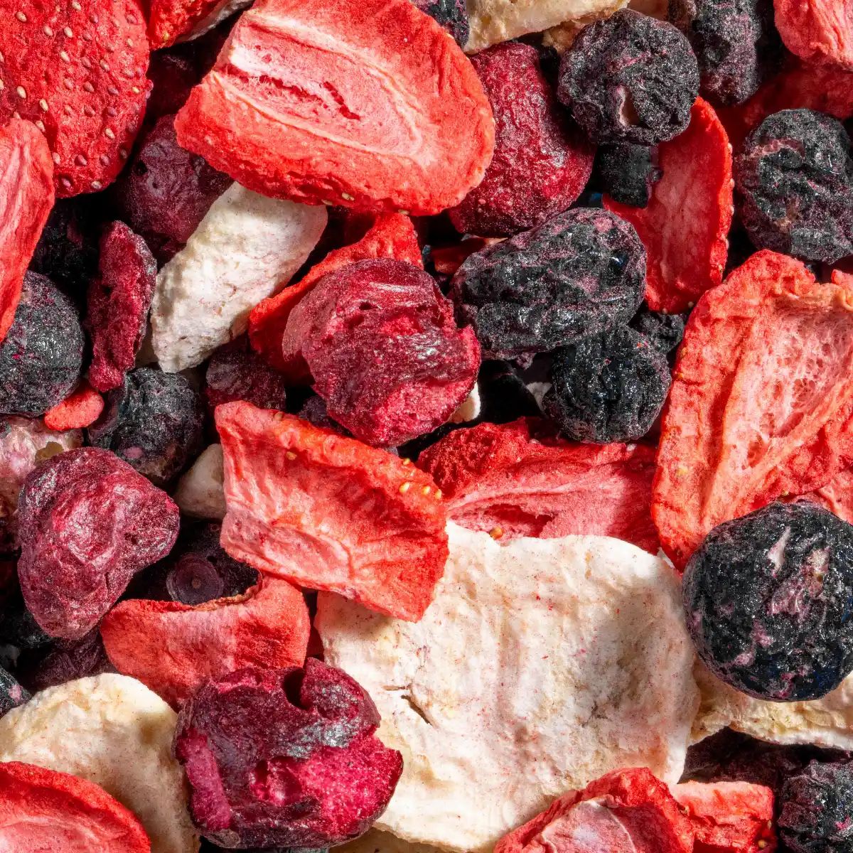 Nahaufnahme von gefriergetrockneten Früchten: Erdbeeren, Blaubeeren und Bananenscheiben.