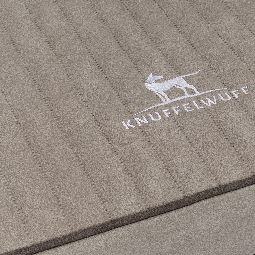 Detailaufnahme der gesteppten Oberfläche einer Hundematte. Das Logo ist sichtbar.