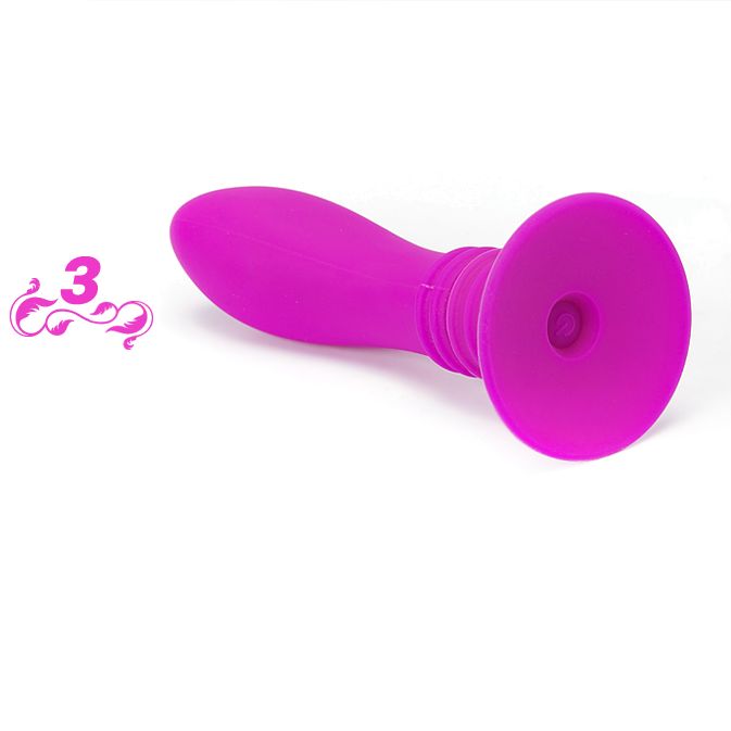 Pinkfarbener Anal Plug mit Saugnapf. Geriffelter Schaft. Auf flacher Oberfläche liegend.