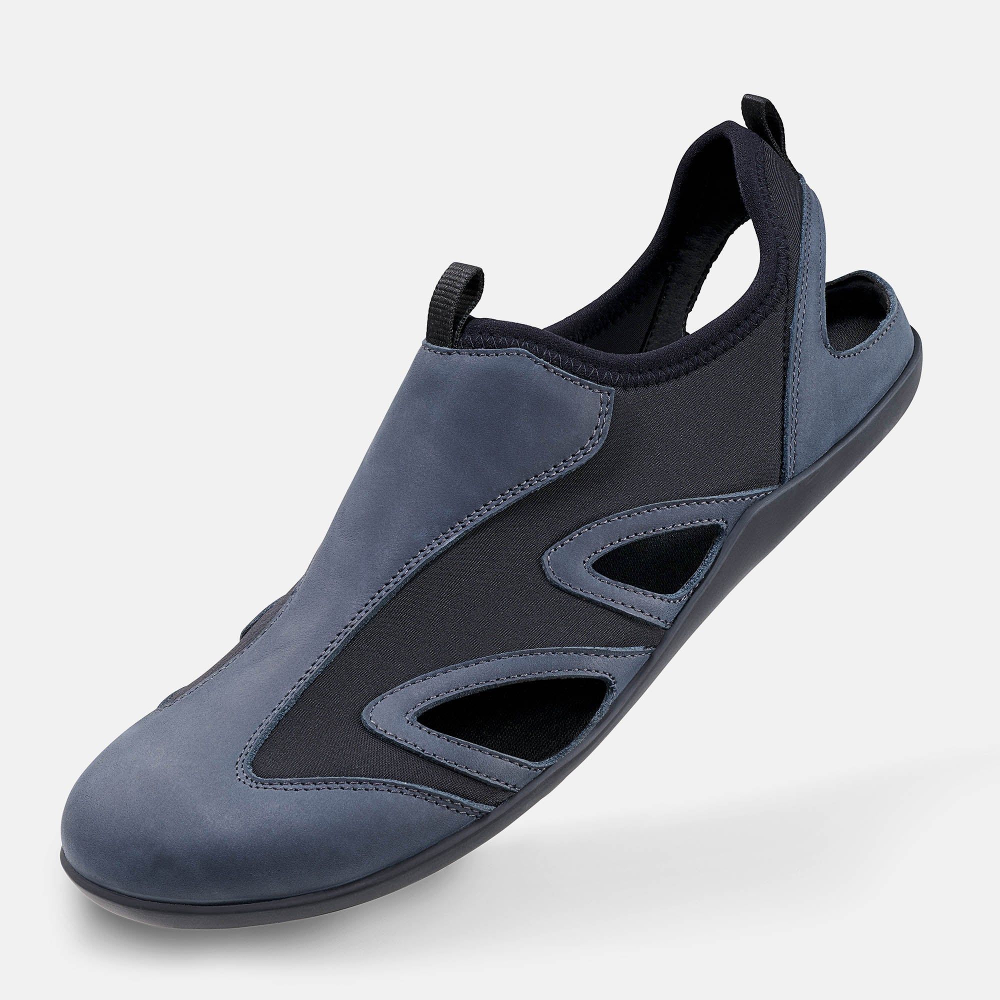 Blaue Sandale mit schwarzem Einsatz und Aussparungen. Offene Ferse, geschlossene Zehenpartie.