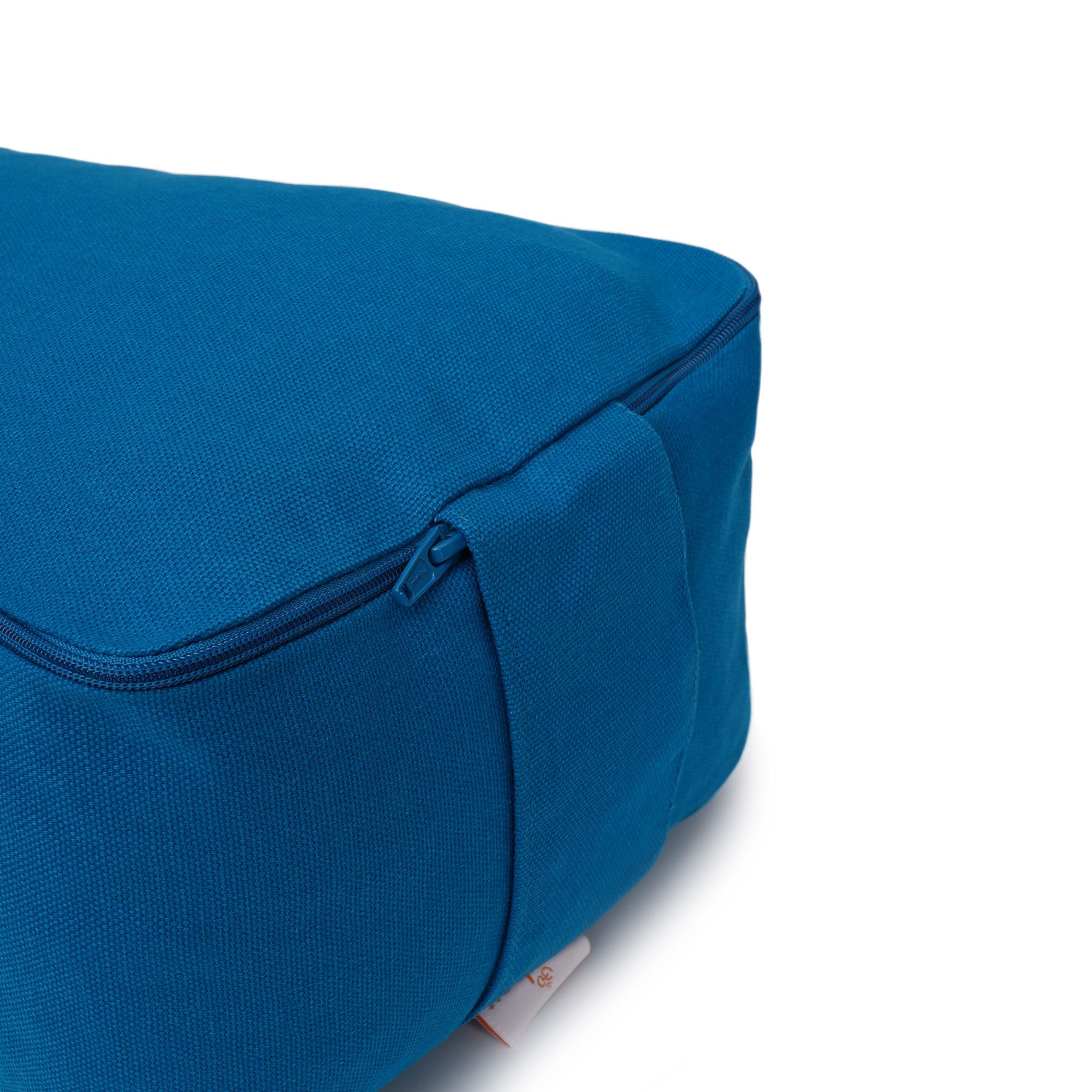 Nahaufnahme des Reißverschlusses an der Seite eines blauen Yogakissens.