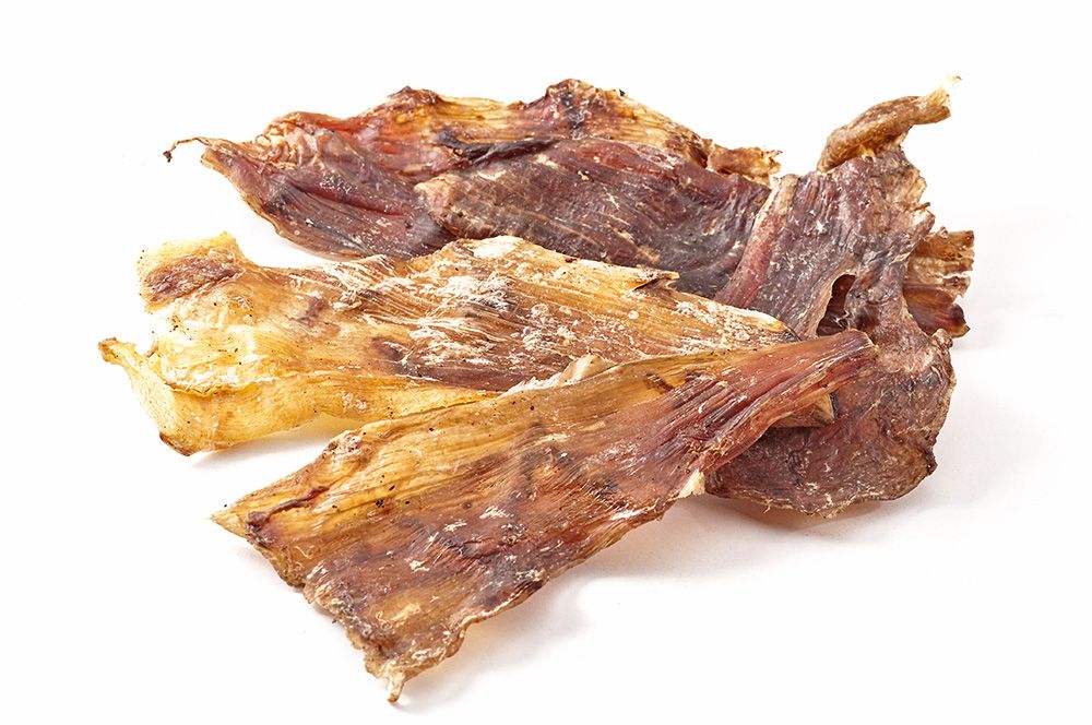 Mehrere Stücke getrockneter, brauner Flachsehne. Einige Stücke sind hellbraun, andere dunkelbraun. Auf weißem Hintergrund.