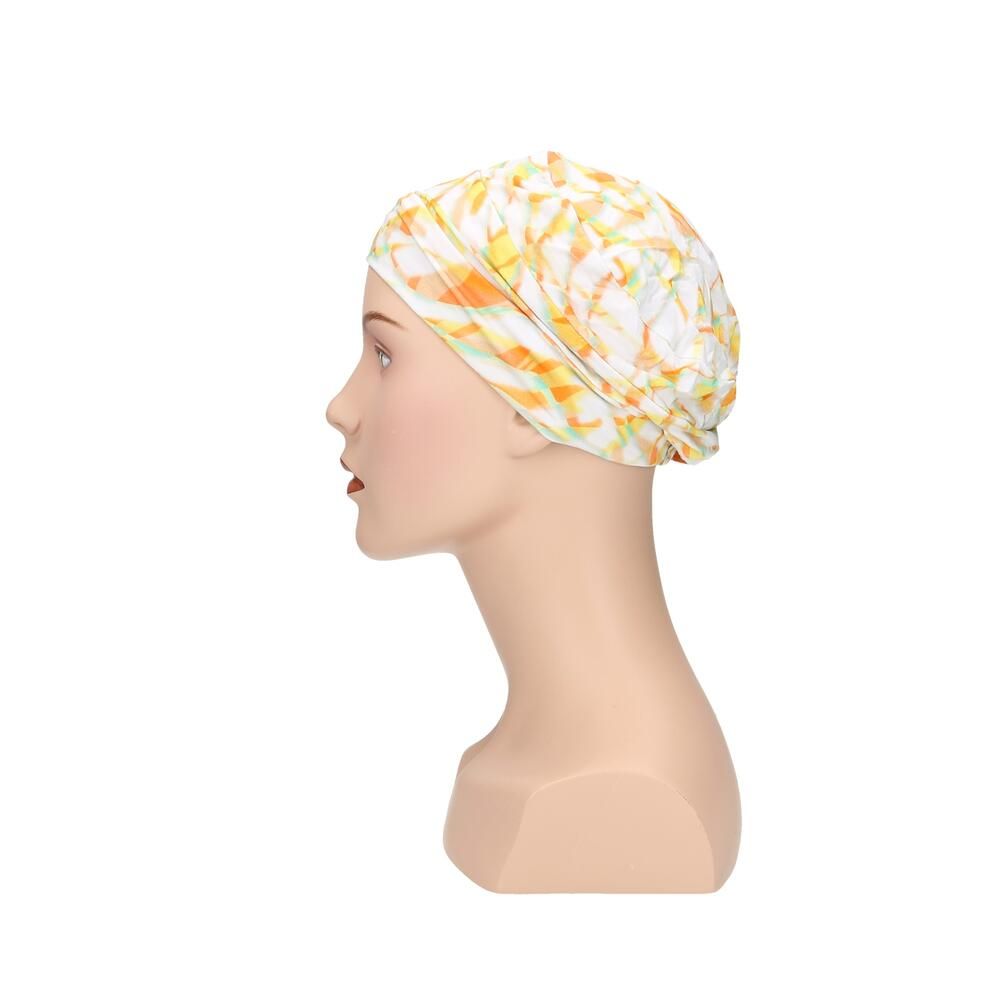 Turban mit gelb-orangenem Muster auf weißem Grund, auf einer Büste. Seitenansicht.